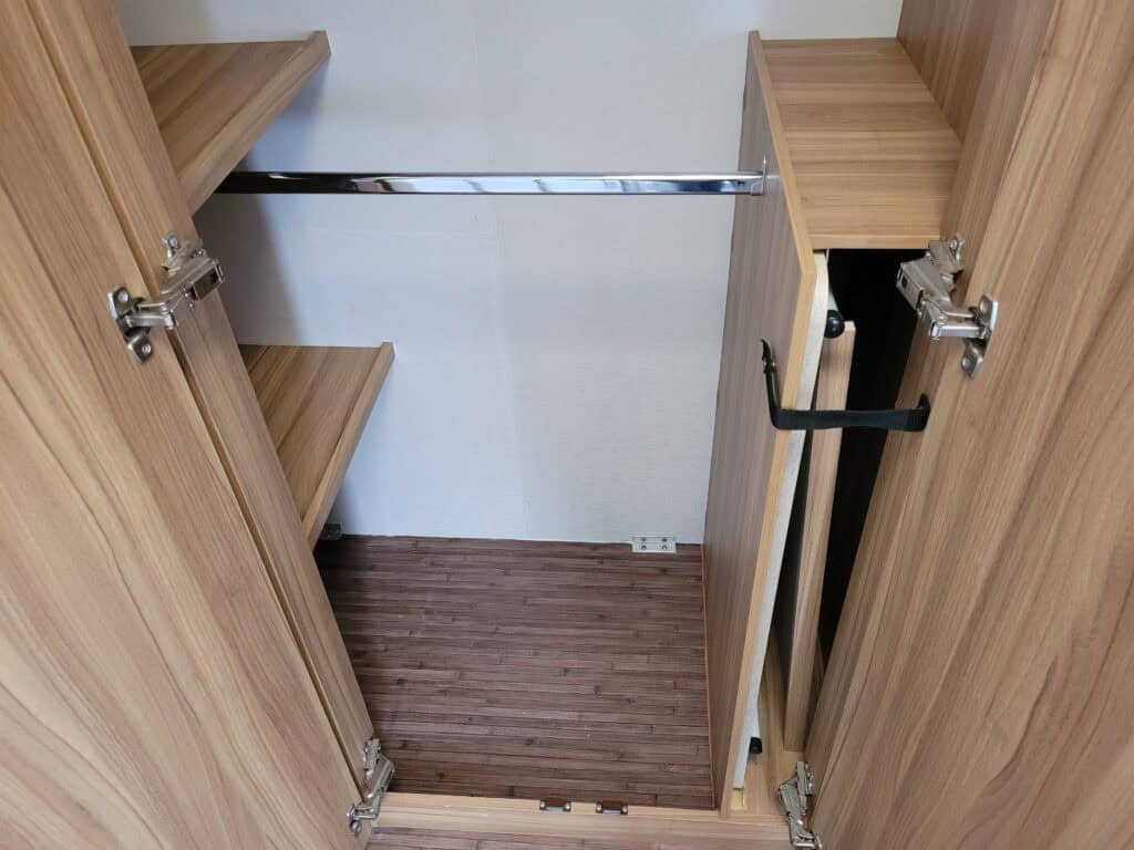 Custom wardrobe interior with wooden shelves and hanging rail for efficient storage.