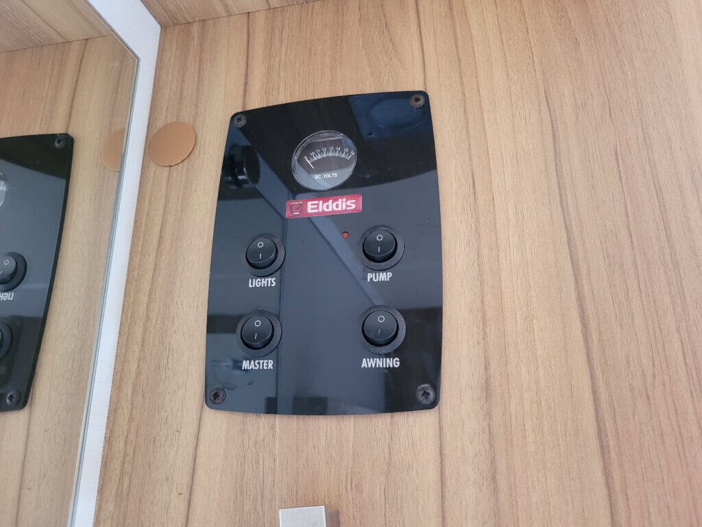 Ridgeway Tourers control panel with gauge and switches on wooden wall.