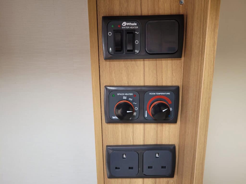 Electrical control panel with switches and sockets inside a caravan or motorhome.