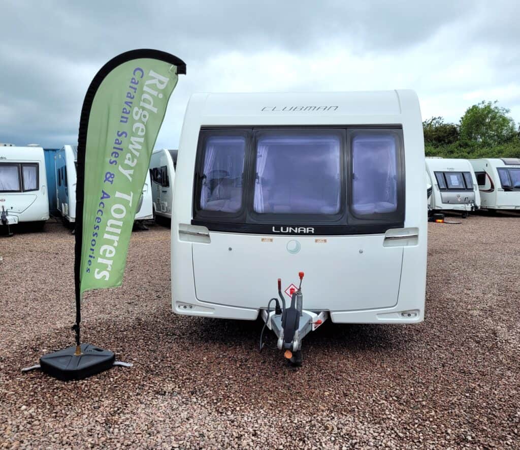 Modern Lunar caravan at Ridgeway Tourers dealership with display flag.