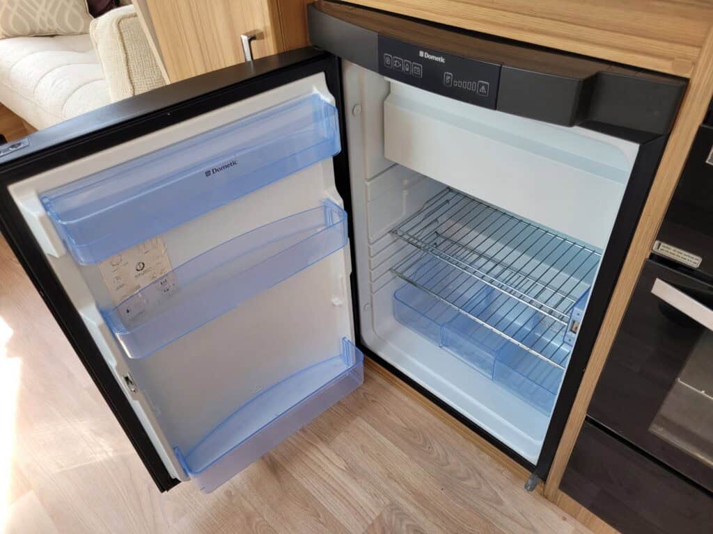 Mini fridge with adjustable shelves, ideal for small spaces and beverage storage.