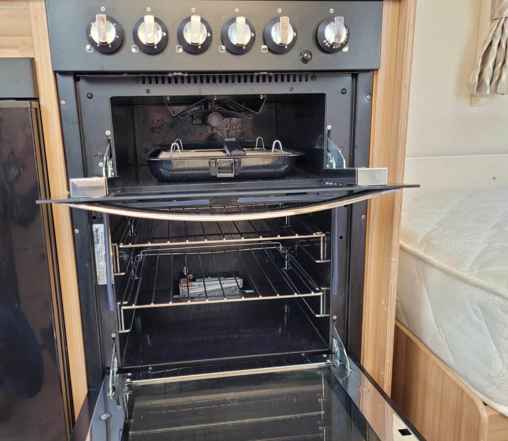 Oven with open door showing interior racks and cooking area.