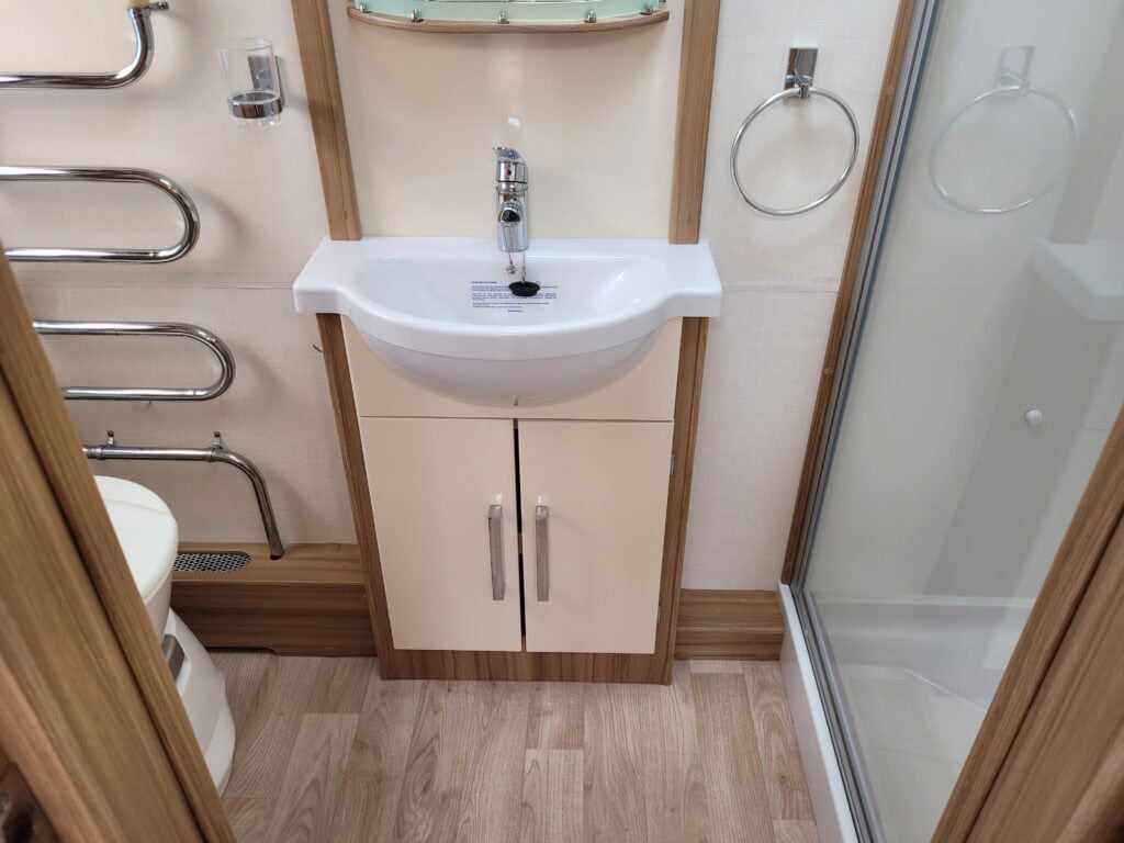 Compact bathroom with sink and shower.