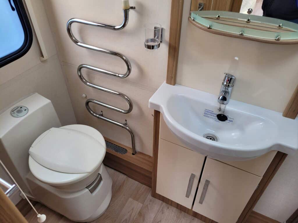 Compact bathroom with toilet and sink in a campervan.