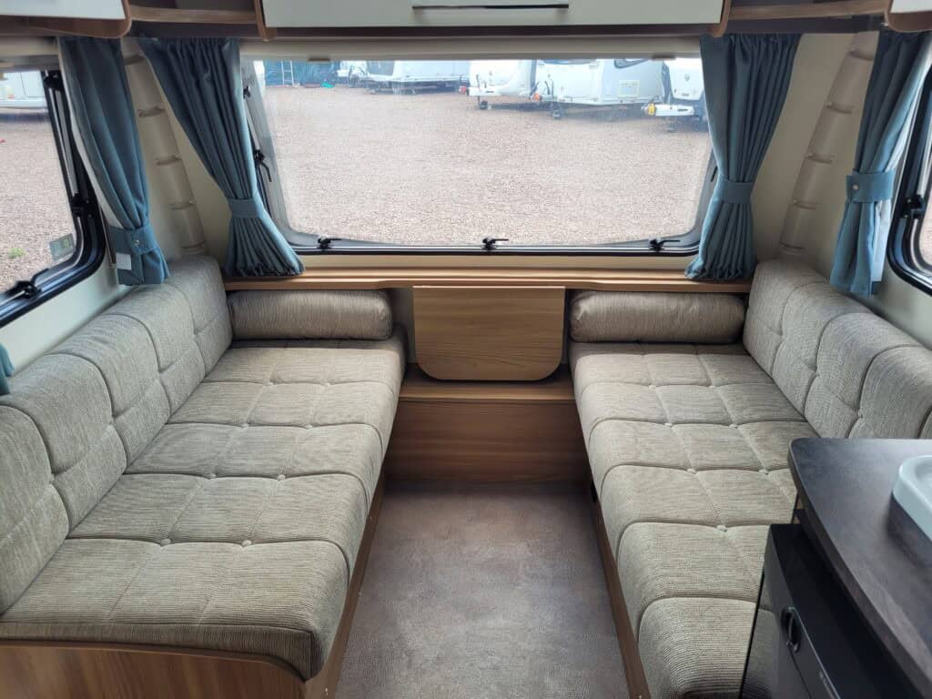 Comfortable caravan interior with spacious seating area and large front window.