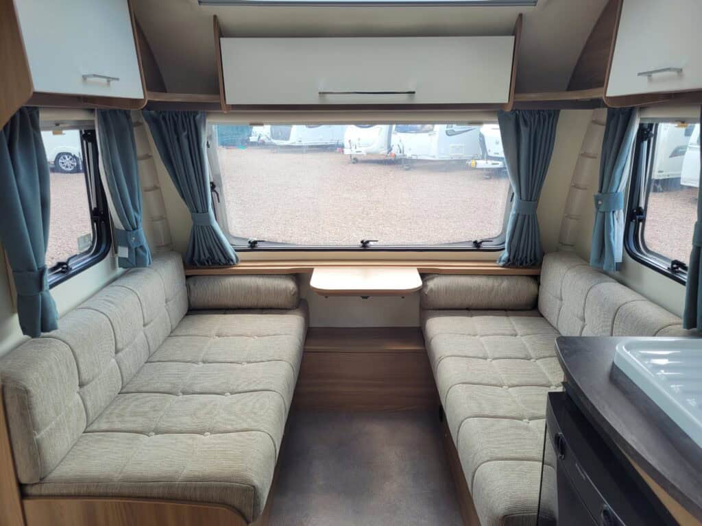Spacious caravan interior with comfortable seating and large windows at Ridgeway Tourers.