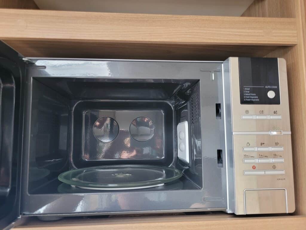 Modern stainless steel microwave oven with digital controls in a contemporary kitchen.